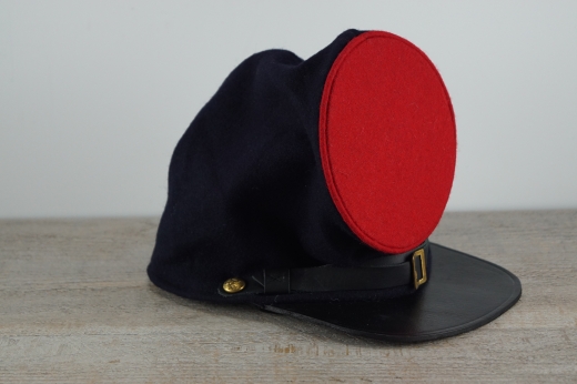 dunkelblaues Bummers Kepi, roter Deckel, auen 100% Wolle, Futter 100% Baumwolle, Schirm / Schweiband 100% Leder